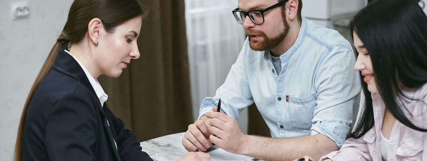 Advisor and a couple reviewing home loan documents together at a desk