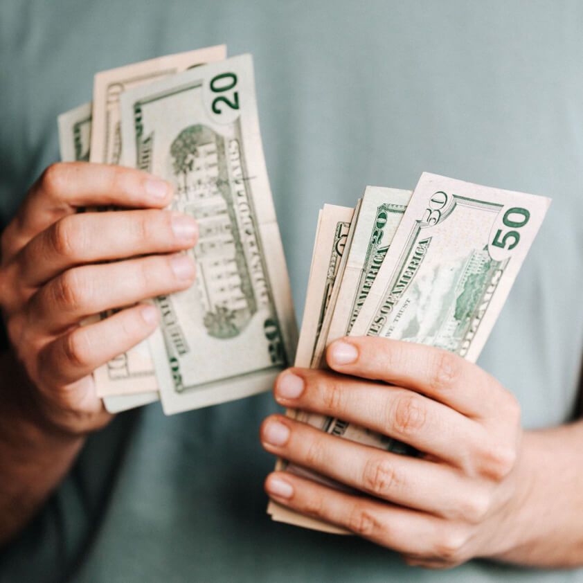 Hands counting banknotes while planning debt repayments