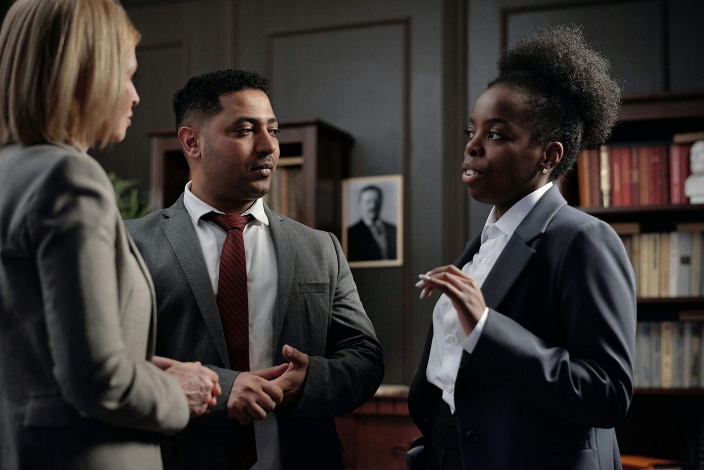 Three professionals discussing finance options in an office