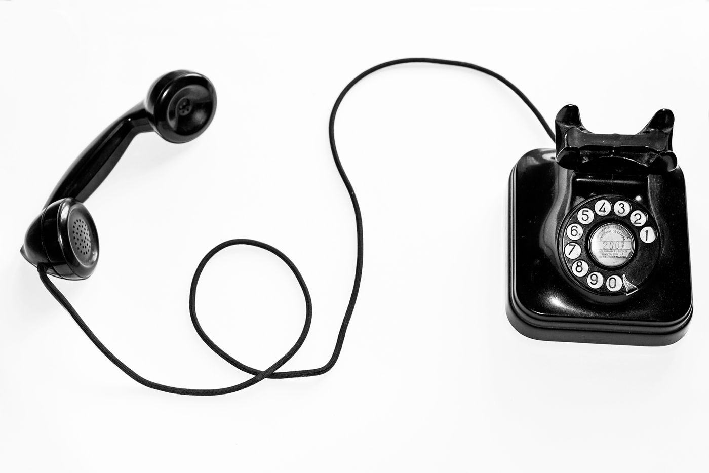 Vintage black telephone on a white background, representing early calls to the insurer and lender