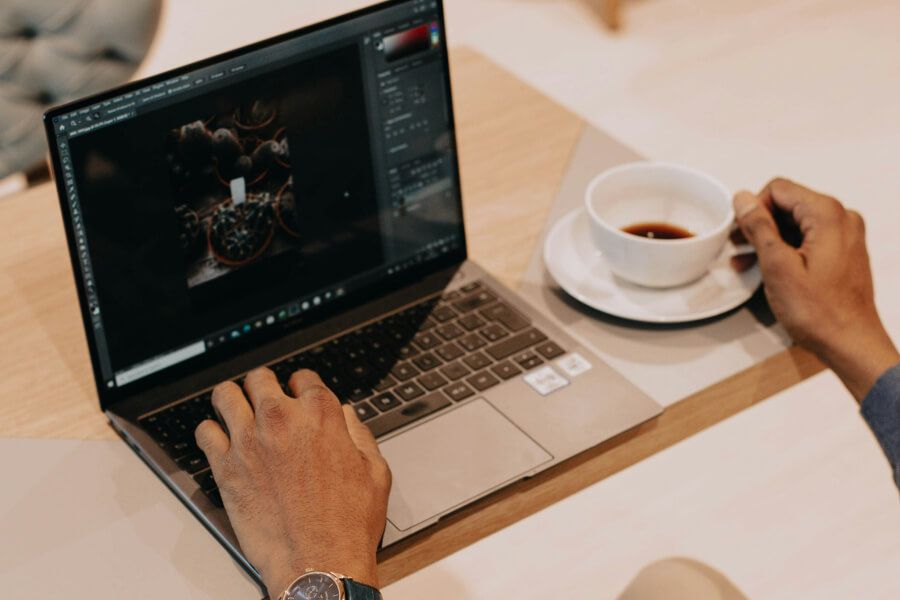 Person comparing loan offers on a laptop with a cup of coffee